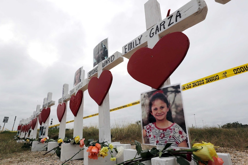 Crosses showing shooting victims' names stand near the First Baptist Church.