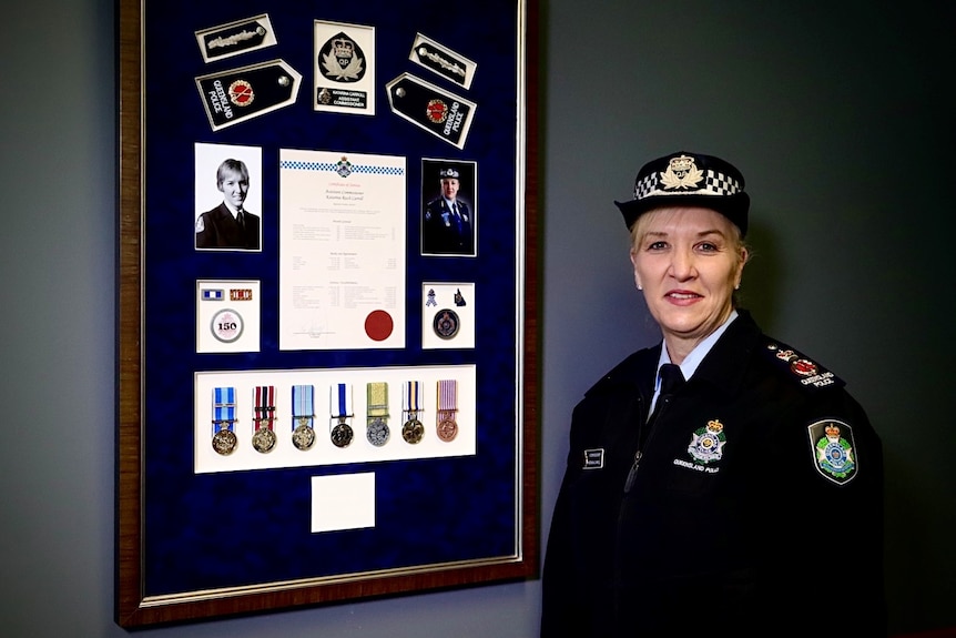 Katarina Carroll standing in front of a board of her achievements.