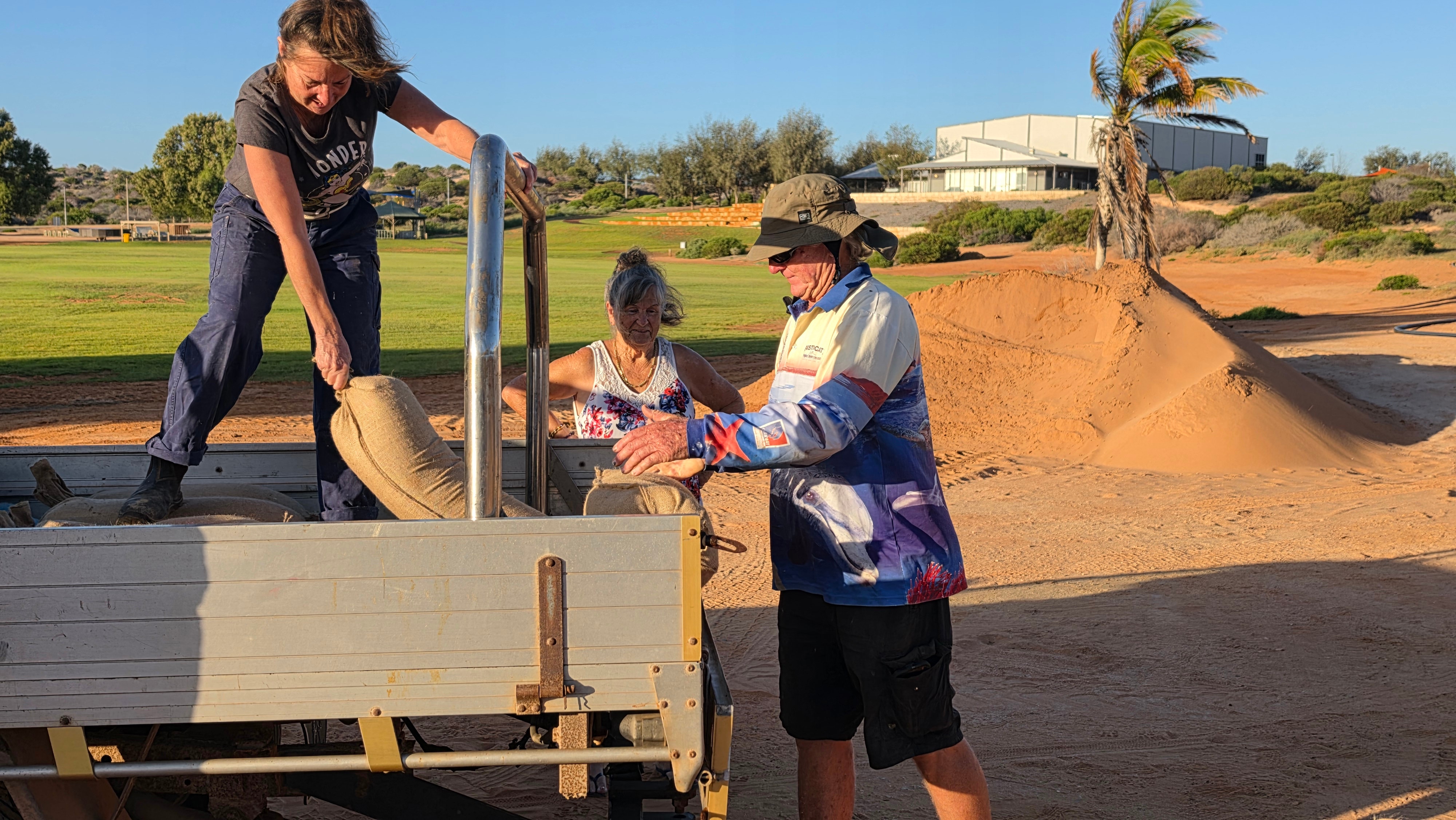 Tres personas cargan sacos de arena desde la parte trasera de un submarino.