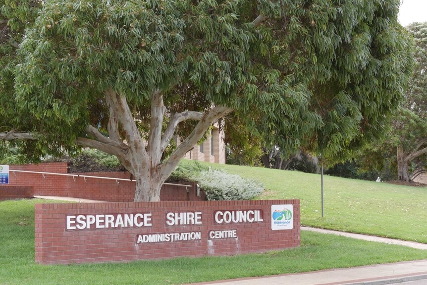 A sign saying "Esperance Shire Council" and a tree and lawn.