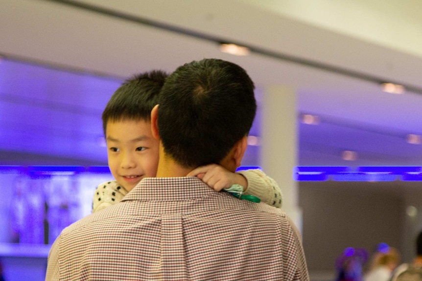 Harley hugs his dad and smiles widely.