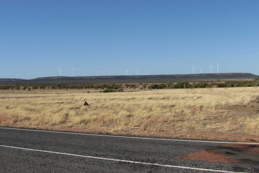 A computer generated picture showing wind turbines in the distance of an outback landscape.