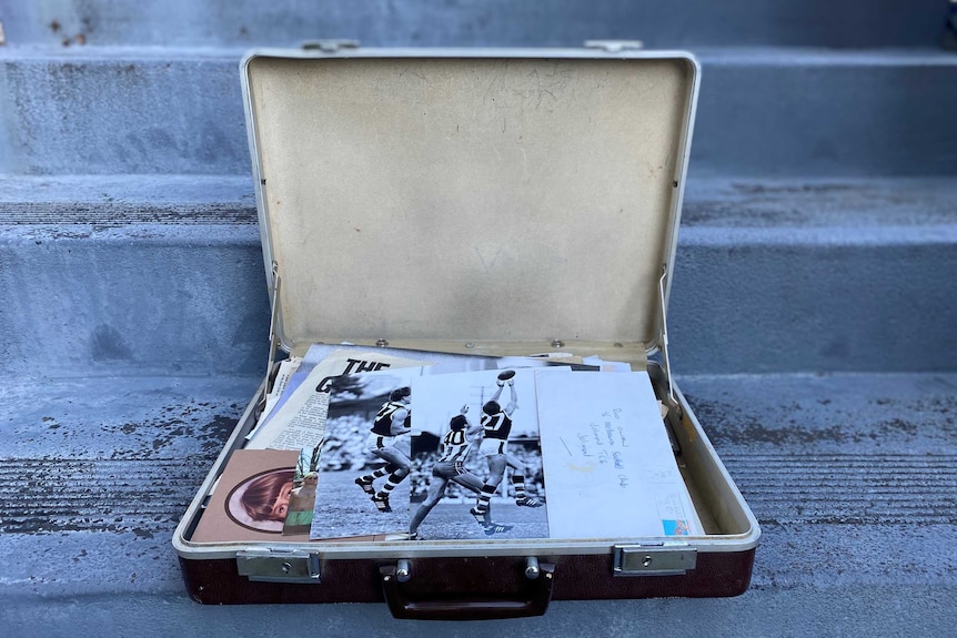 An open briefcase sits on a set of concrete stairs, displaying photographs of Rod Owen during his playing days.