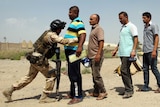 Iraqi civilian men are bodychecked as they volunteer to join fight against ISIS