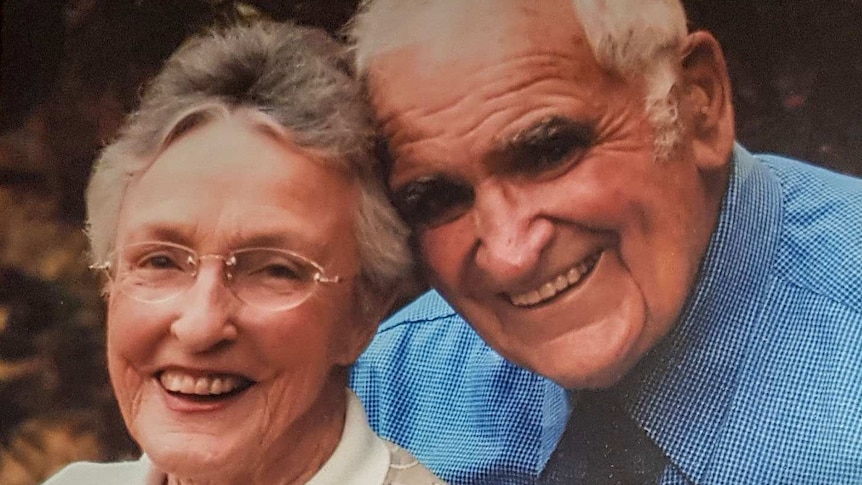 A family photo showing an elderly woman and man, smiling at the camera.