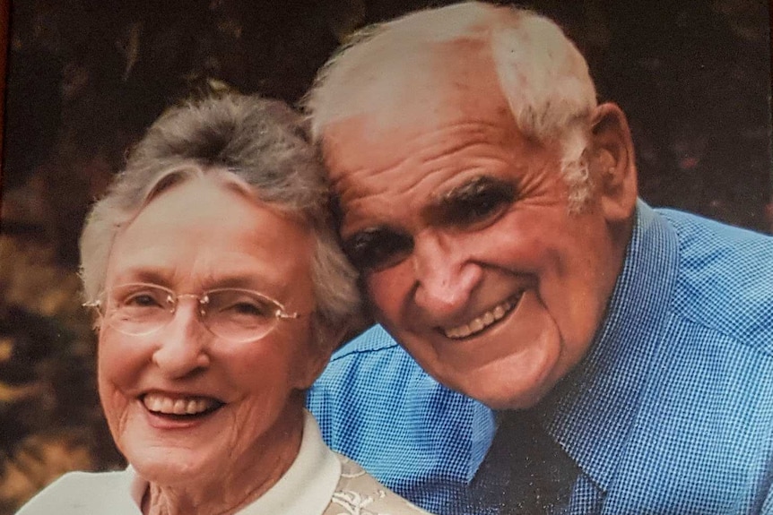 A family photo showing an elderly woman and man, smiling at the camera.