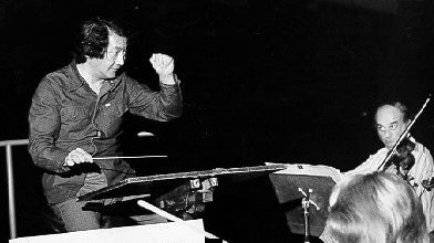 Black and white photo of Hiroyuki Iwaki conducting orchestra.