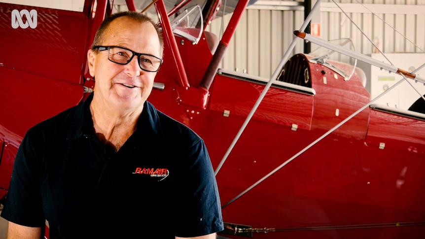 Man sitting by a biplane