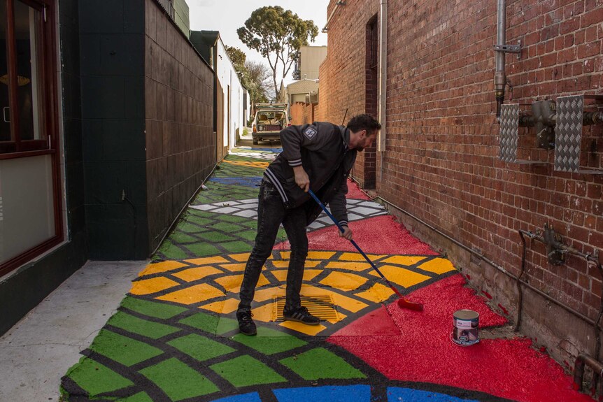 Artist Drew Straker works on a laneway off Beaufort Street, 13 August 2014.