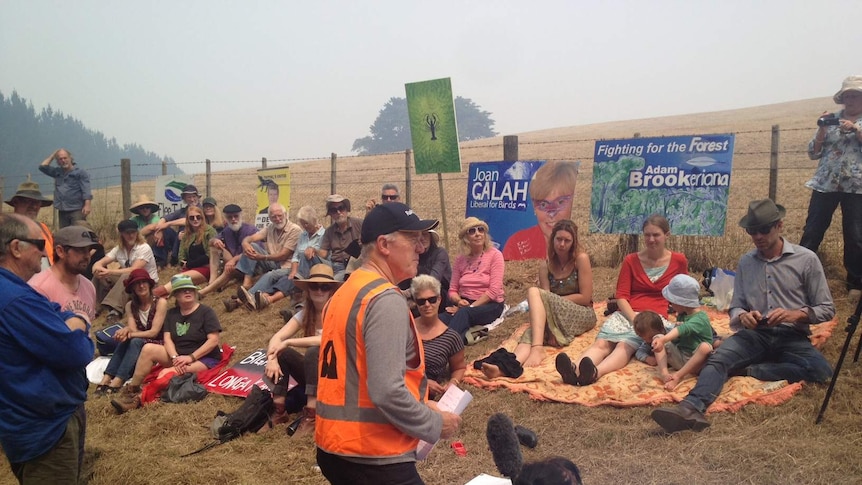 Protesters near the Lapoinyah forest coupe sitting in front of fence.