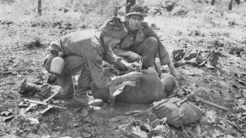 Australian soldiers tend a wounded comrade after the battle of Long Tan in August 1966
