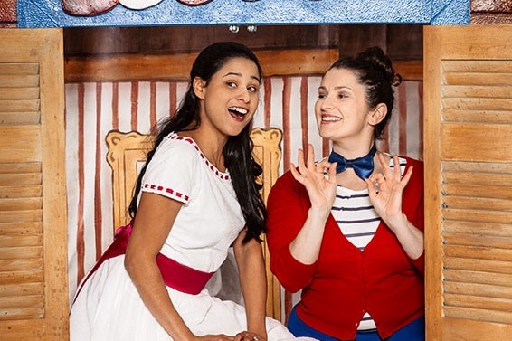 Stacey Alleaume in the Barber of Seville sitting on a window ledge next to her Shadow Interpreter Maxine Buxton.