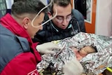 Paramedics comfort a 10-day-old baby boy in an ambulance.
