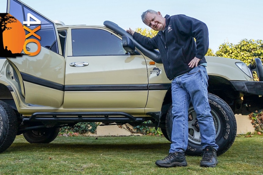 a man leaning on a larhe brown four wheel drive car.