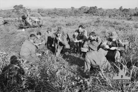 A black and white image of uniformed men in a paddock
