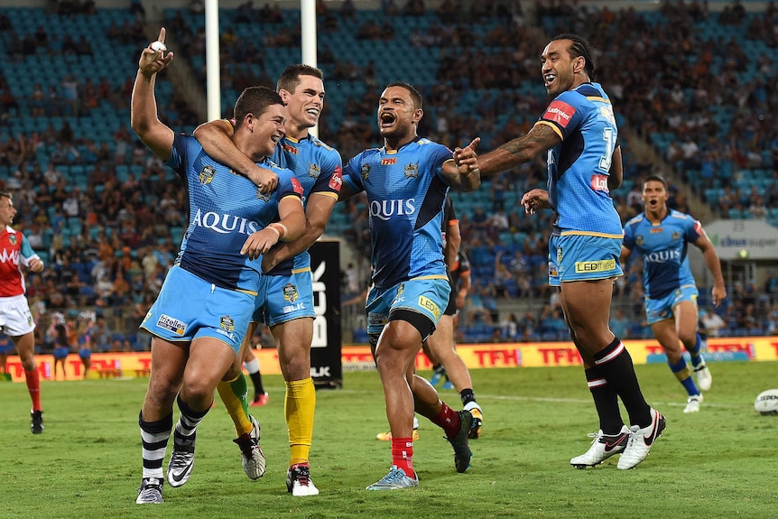 Titans player Ashley Taylor (left) celebrates after scoring a try during the Round 3 NRL match