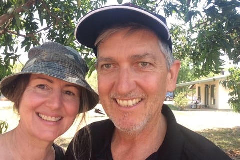 two people standing under a tree taking a selfie