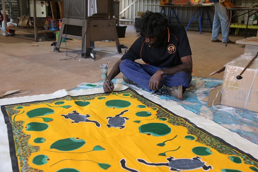 Christopher Tcherna painting a long neck turtle painting on canvas.