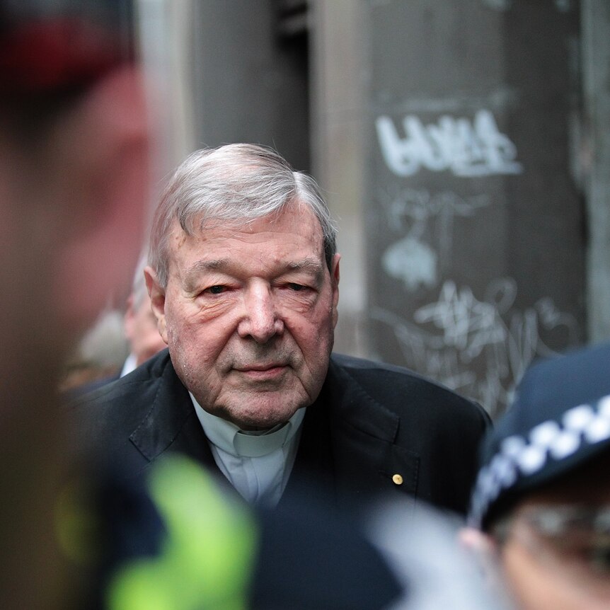 Cardinal George Pell escorted by police arrives at the Melbourne Magistrates' Court