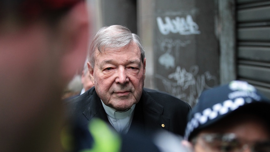 Cardinal George Pell escorted by police arrives at the Melbourne Magistrates' Court