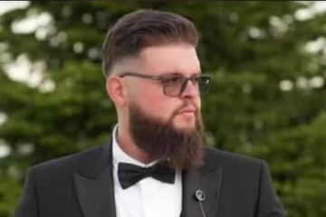 A man with a beard wearing glasses and a bow tie