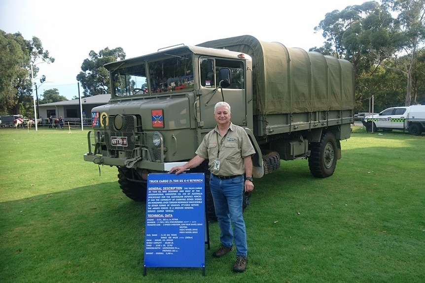Paul Dekmetzian stands in front of the 'blitz' truck beside a sign, parked at a sporting club oval.
