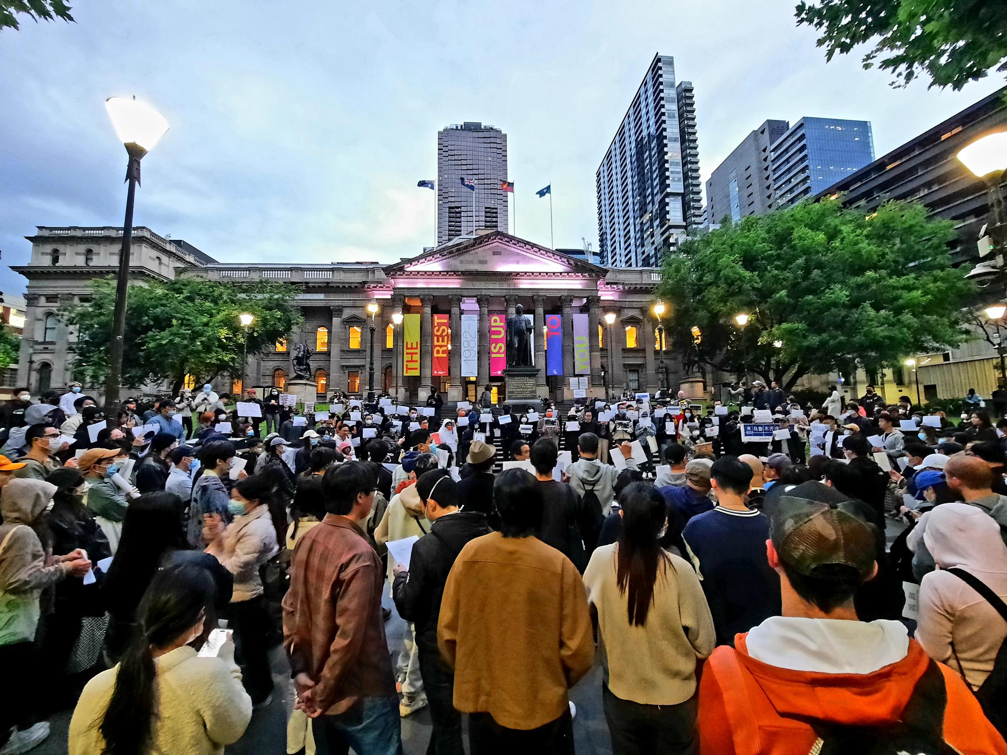 一群人聚集在墨尔本市中心的州立图书馆外进行抗议。