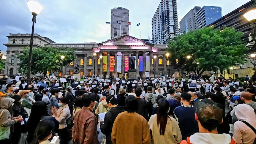A crowd of people gather for a protest outside the state library in Melbourne CBD. 