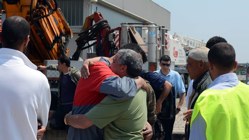 Italian workers comfort each other after quake