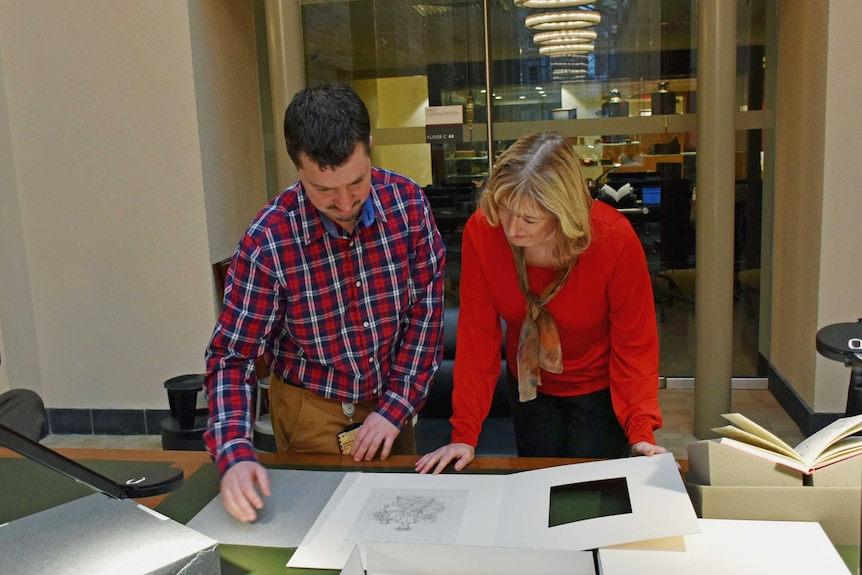Dr Margaret Baguley with special collections officer Charles Doran looking at the original Mary Poppins illustrations.