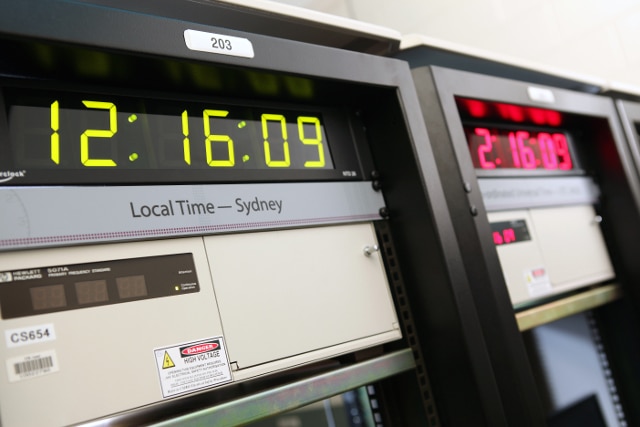 large clocks with digital time faces above computer terminals