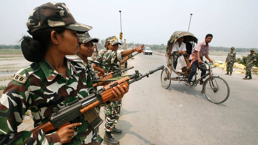 Indian female paramilitary soldiers hold rifles.
