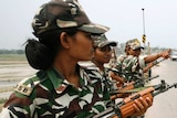 Indian female paramilitary soldiers hold rifles.
