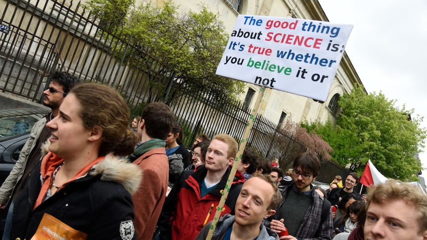 A man holds a placard in support of science during a pro-science march