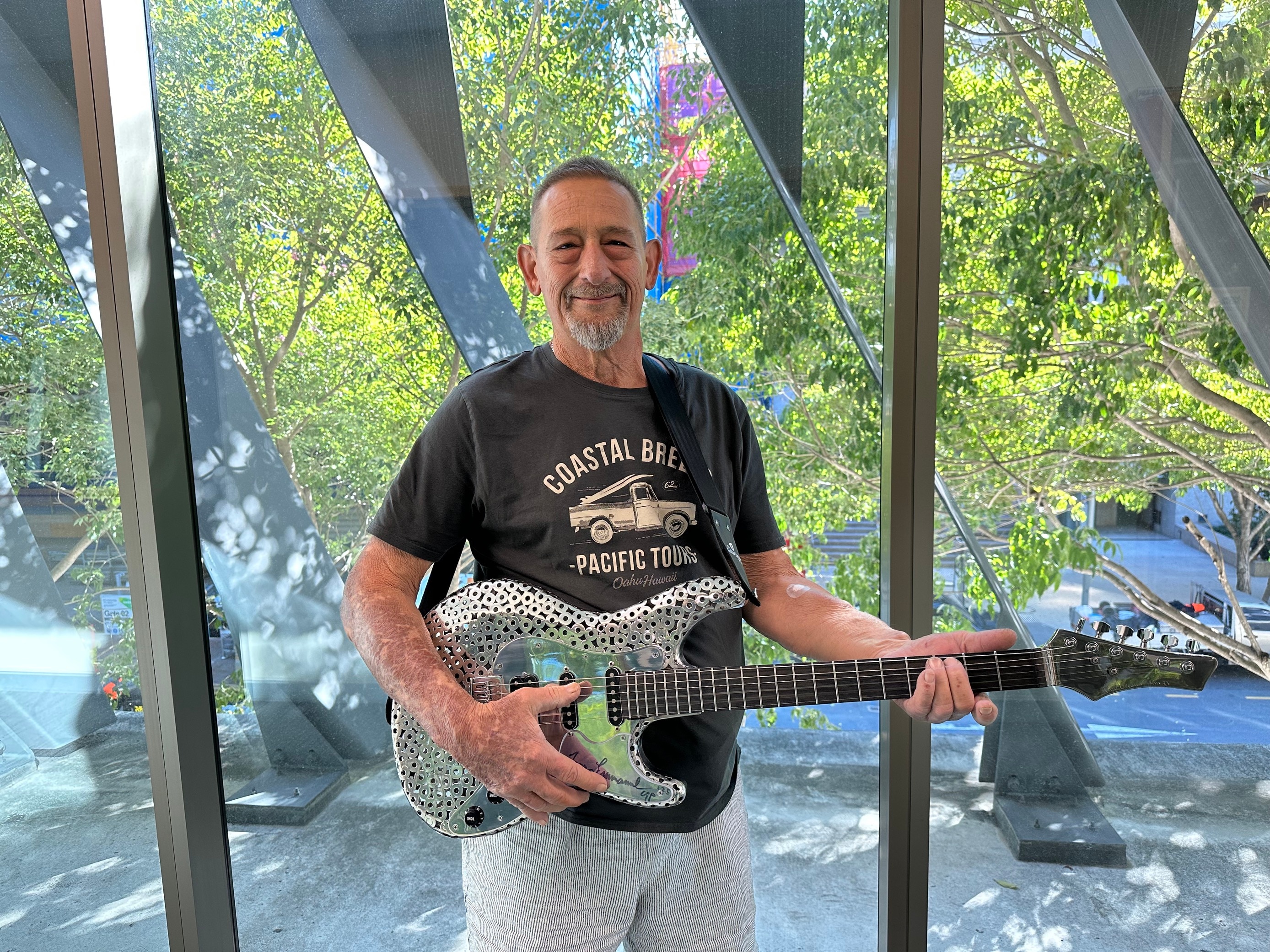 an image of eddie rigo holding his metal guitar