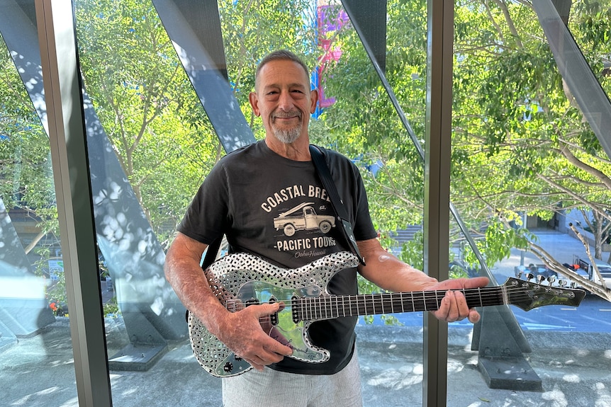 an image of eddie rigo holding his metal guitar