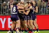 The Dockers at Perth Stadium hugging each other after a game.