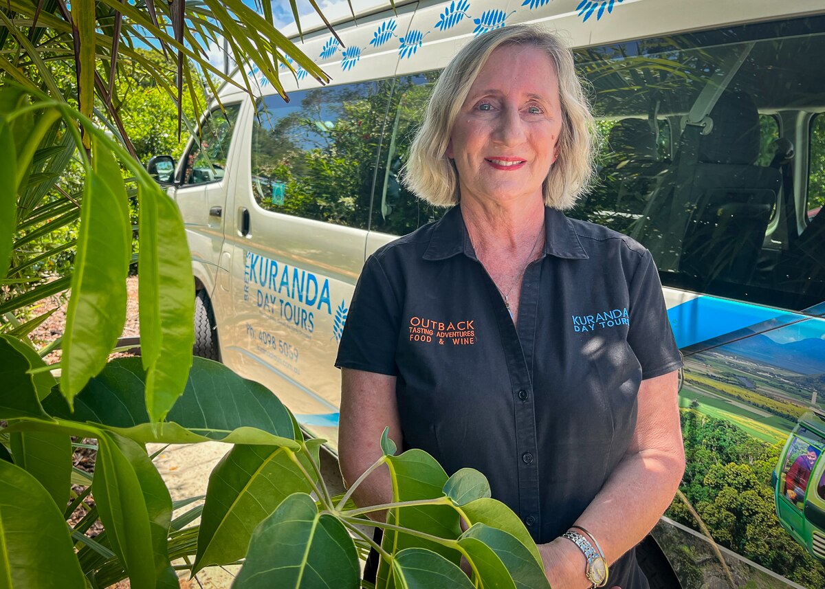 Andrea Cameron stands in front of a tour bus