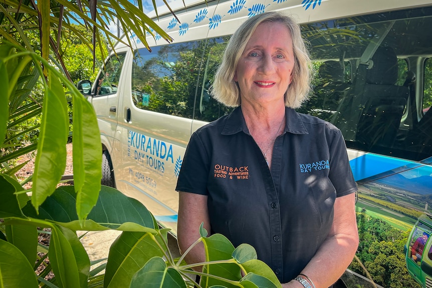 Andrea Cameron se para frente a un autobús turístico