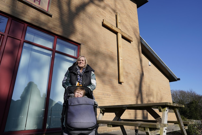 A woman stands outside a church.