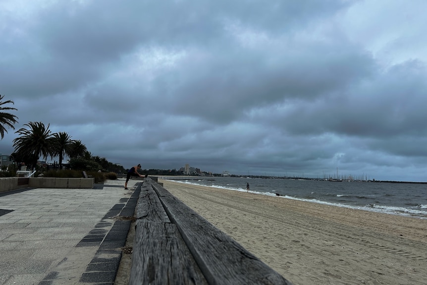 Stormy clouds over dark murky water at a beach in Port Melbourne.