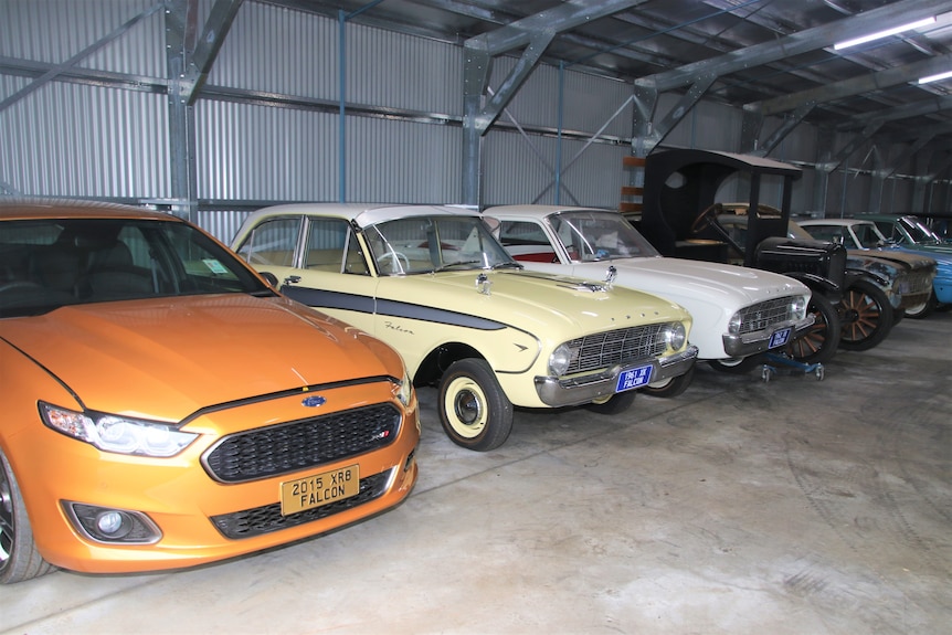 A later model orange falcon sitting besides 2 falcons from the 1960's and a Modell TT Ford