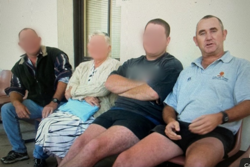 Four people sit in a row.  Three have their faces blurred.  The fourth is a man wearing a light blue polo shirt.