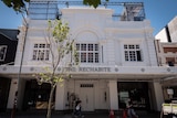 The Rechabite exterior - large white heritage building with people walking past.