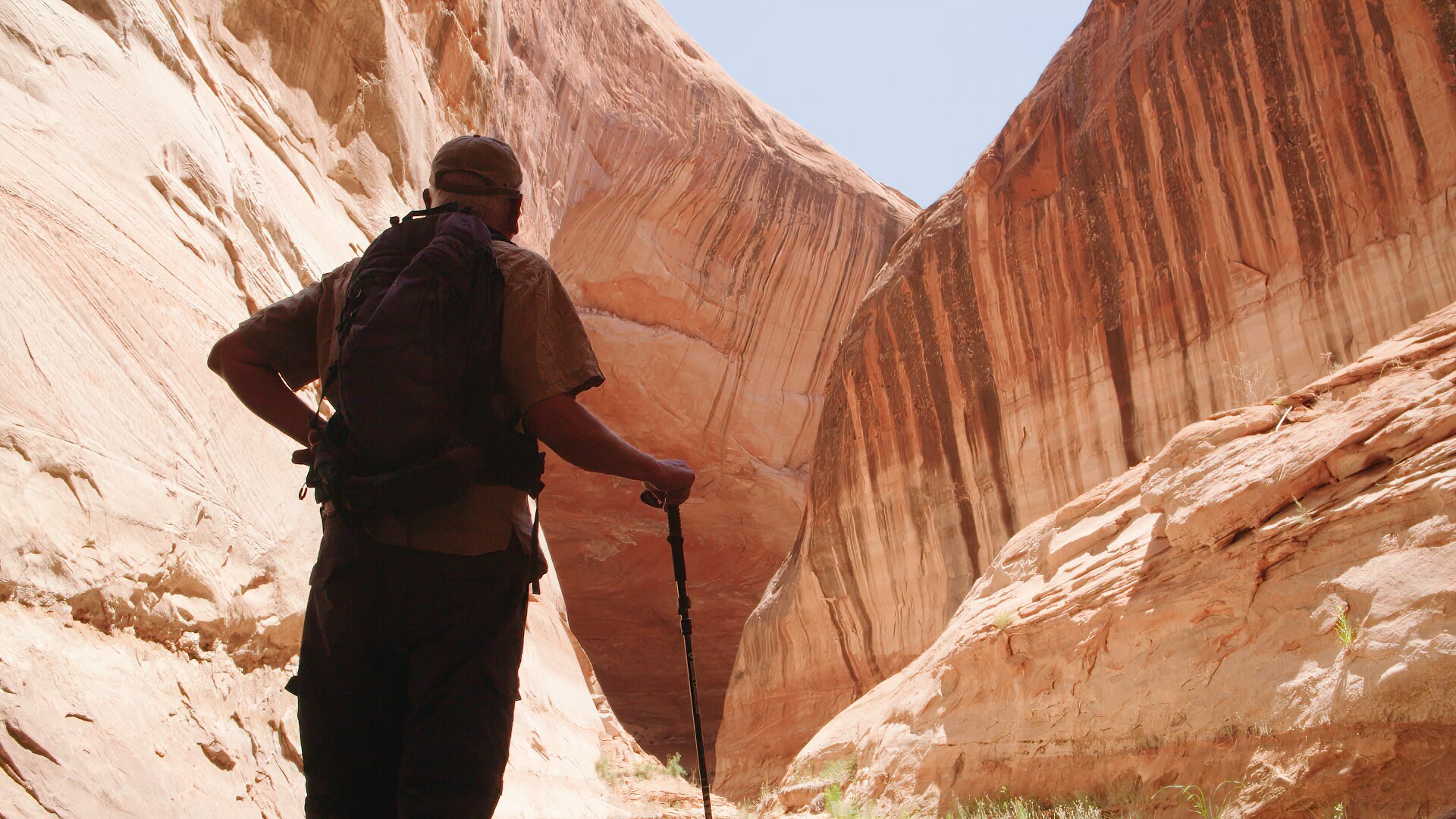 A man looks at a giant rock formation.