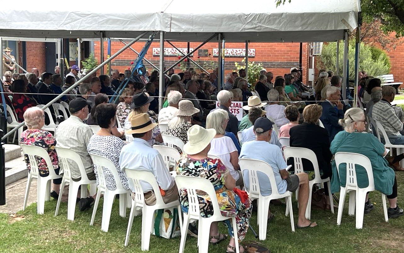 A group of people sitting down at a community event 