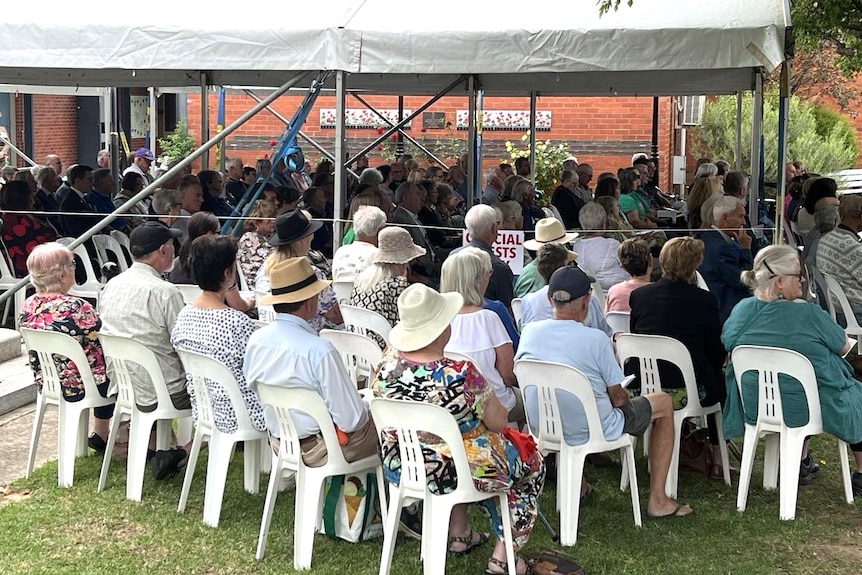 A group of people sitting down at a community event 
