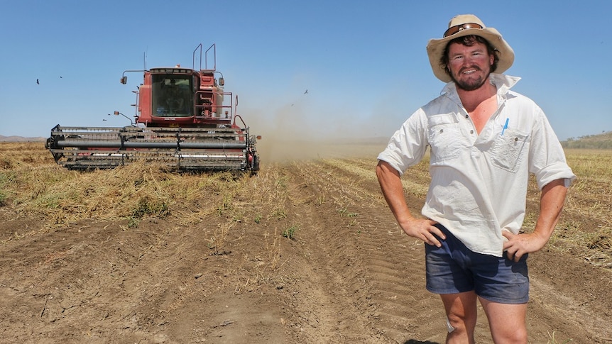 KAI farm manager Luke McKay standing in front of the header as it harvests chia in the Ord.