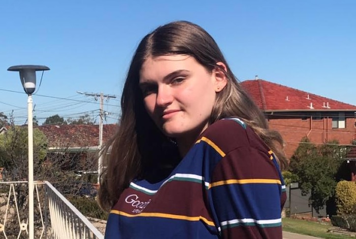 A teenage girl leaning on a balcony