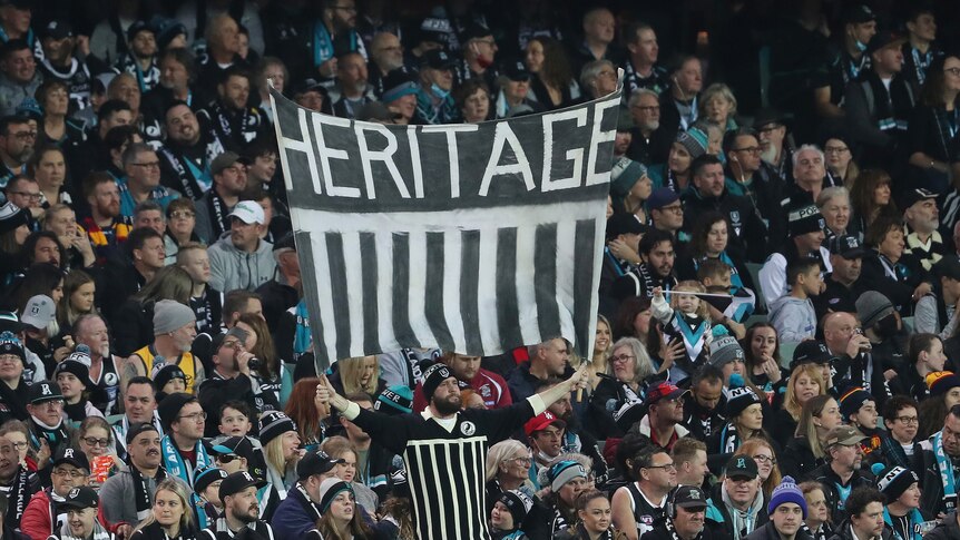 A fan in the crowd holds a banner that says heritage